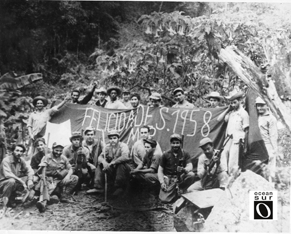 Che con combatientes de la Columna 4 posan alrededor de una bandera colocada en El Hombrito, 1957