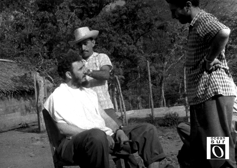 Fidel conversa mientras lo pelan, en una improvisada barbería en El Naranjo, Sierra Maestra.