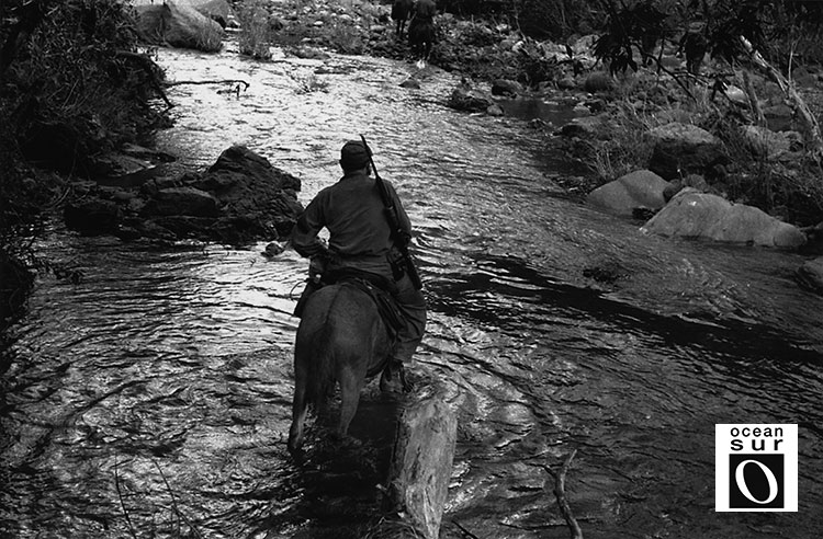 Fidel cruza un río de la Sierra.