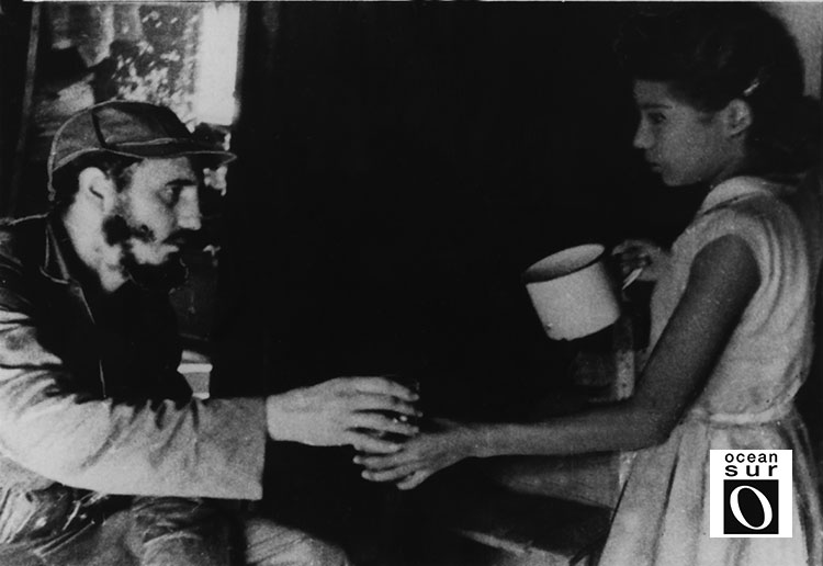 Una niña le sirve a Fidel un vaso de agua en una casa de la zona.